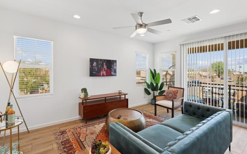 a living room with a blue couch and glass balcony door